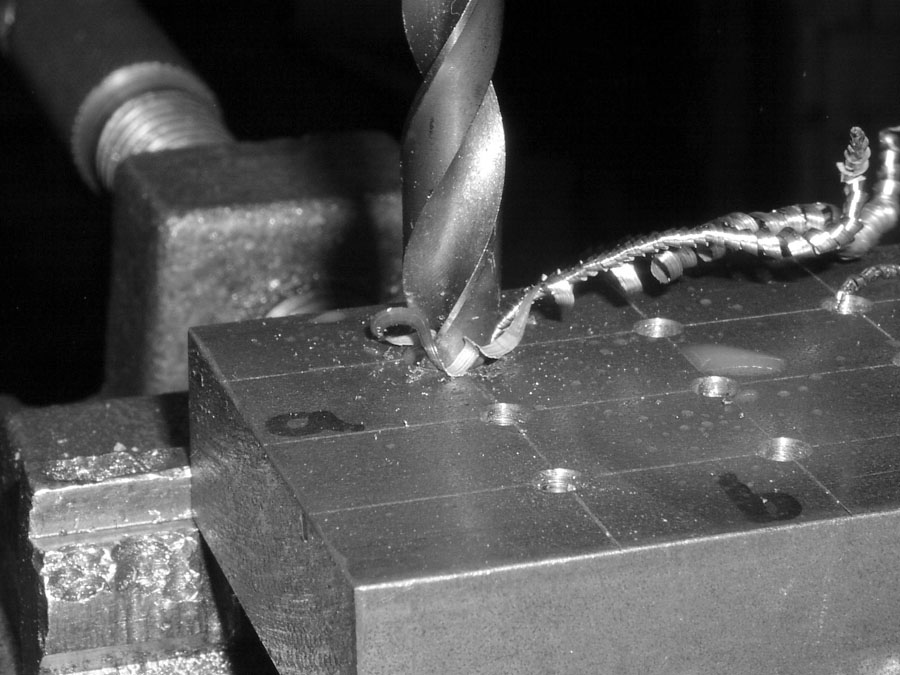 Bohren in eine Stahl-Platte mit einer Säulenbohrmaschine