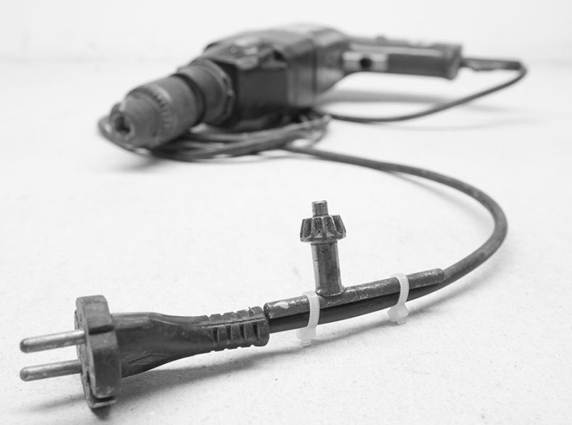 Bohrfutterschlüssel am Kabel der Bohrmaschine