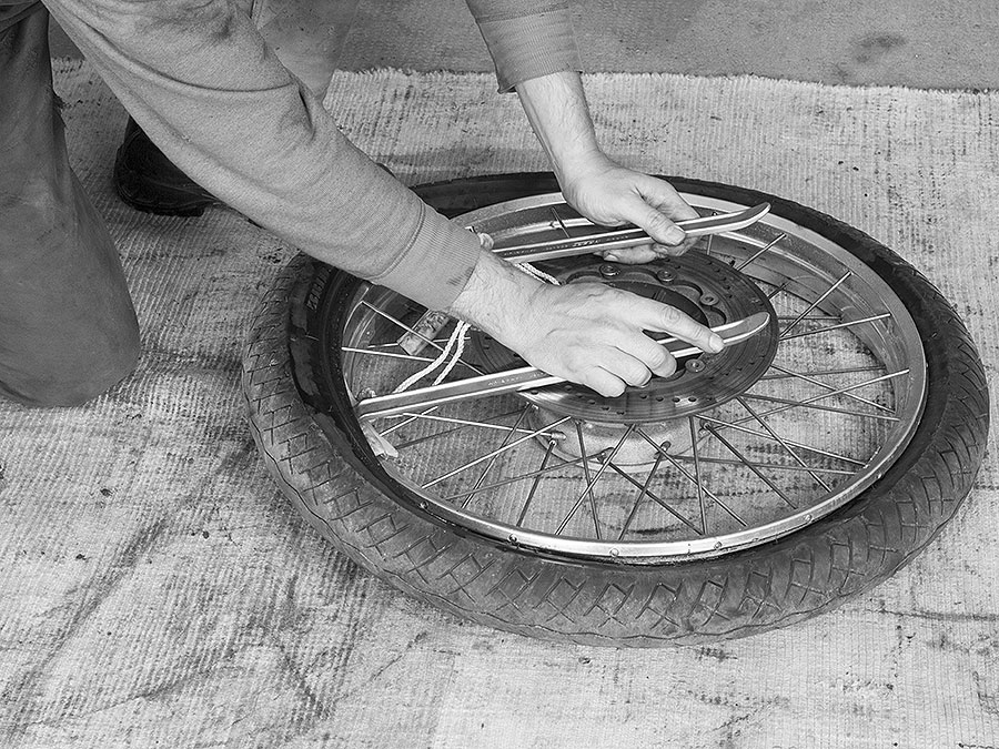 Alten Reifen von der Felge heben