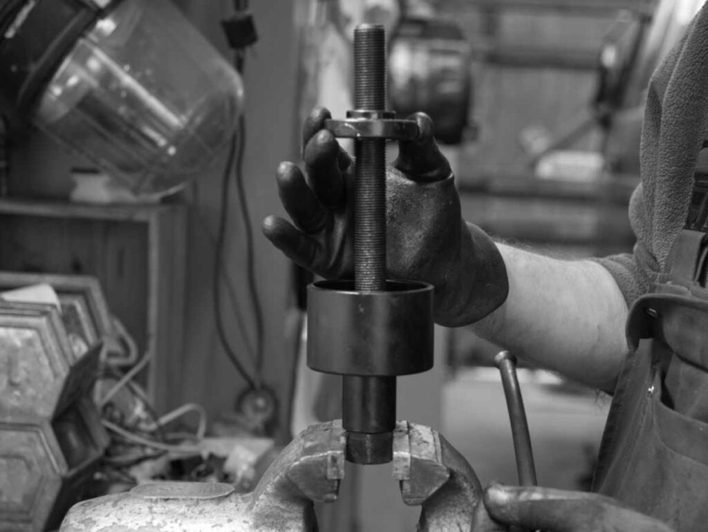 kleine Spindelpresse im Schraubstock an der Werkbank um die Radlager auzupressen