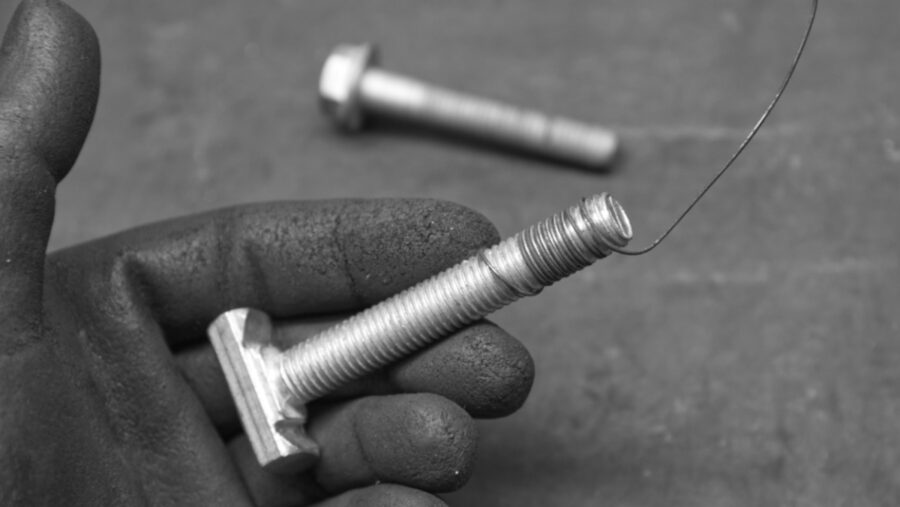 Schraube mit ein bisschen Draht von hinten durch eine Bohrung fädeln