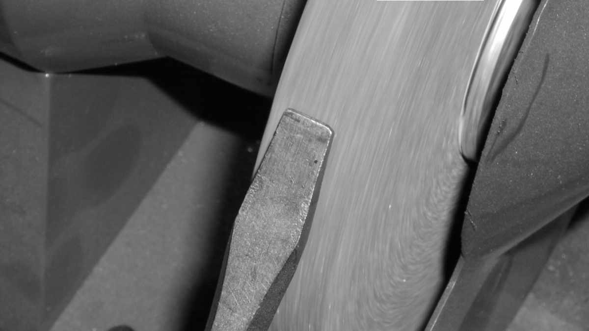 Schlitz-Schraubendreher an einem Schleifstein wieder anschleifen